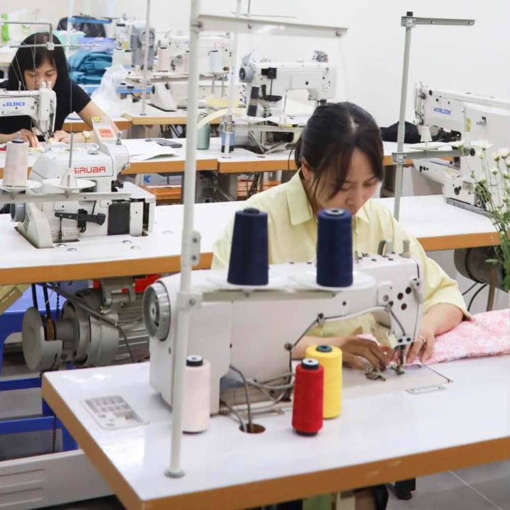 Workers operating sewing machines in a factory setting
