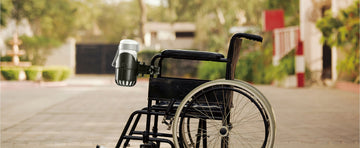 Wheelchair with cup holder on a paved path