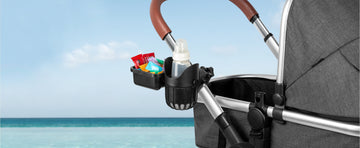 Stroller cup holder securely carrying drinks and snacks for a beach day, showcasing hands-free convenience 