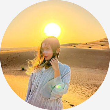 A mom in a desert landscape with a large sun in the background