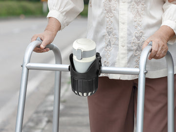 Adult using walker with attached cup holder for hands-free drink convenience