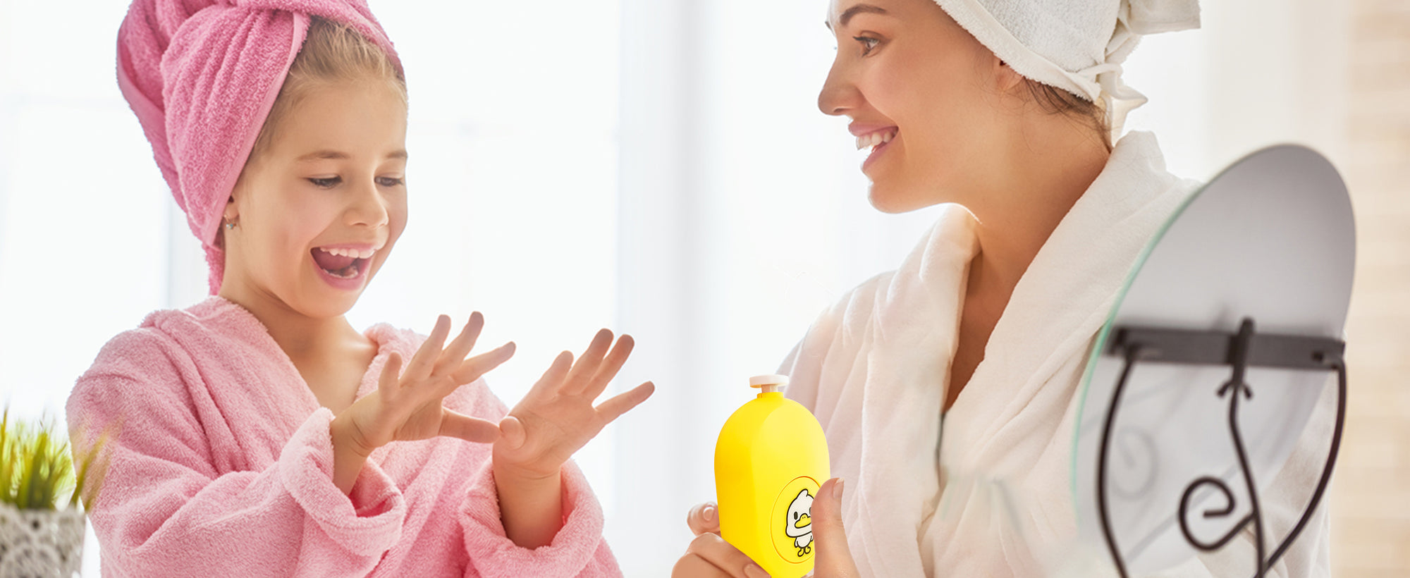 Mother and child in robes after nail care, with infant showing clean nails and holding yellow baby nail trimmer