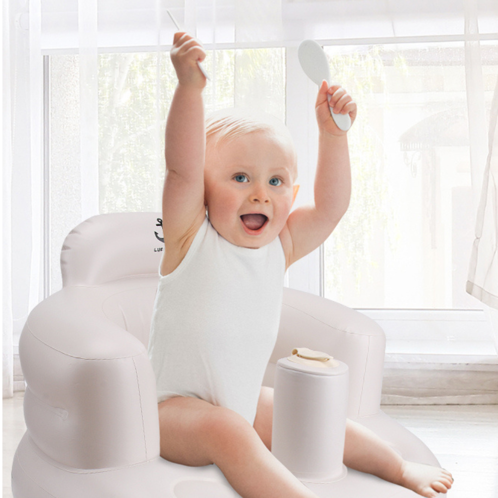 A baby in a cozy white outfit sits attentively in a LUFFCABO inflatable baby seat, awaiting lunch in a safe and supportive baby chair 